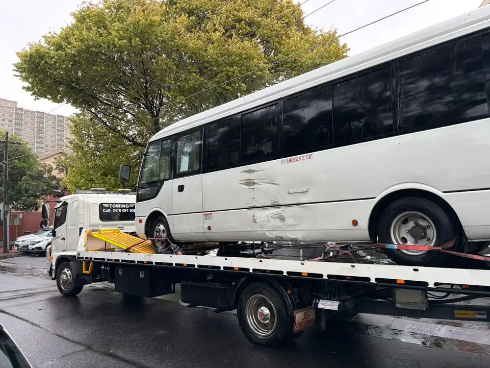 Southern Towing recovery truck transporting a damaged bus through Melbourne during a 24/7 emergency towing response